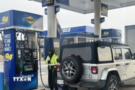 Nhân viên phục vụ khách hàng tại một trạm xăng ở bang New Jersey, Mỹ. (Ảnh: Đoàn Hùng/TTXVN)