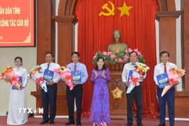 Bà Châu Thị Mỹ Phương, Chủ tịch Hội đồng Nhân dân tỉnh Tiền Giang (thứ ba, phải sang) trao Nghị quyết của Hội đồng nhân dân tỉnh về việc thành lập 5 sở mới. (Ảnh: Hữu Chí/TTXVN)
