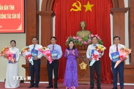 Bà Châu Thị Mỹ Phương, Chủ tịch Hội đồng Nhân dân tỉnh Tiền Giang (thứ ba, phải sang) trao Nghị quyết của Hội đồng nhân dân tỉnh về việc thành lập 5 sở mới. (Ảnh: Hữu Chí/TTXVN)