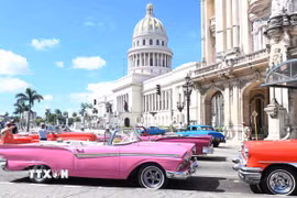 Dàn xe cổ đợi khách trước Nhà hát lớn La Habana, bên cạnh tòa nhà Quốc hội Cuba. (Ảnh: Việt Hùng/TTXVN)