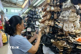 Tiểu thương chợ Đống Đa, thành phố Đà Nẵng ứng dụng zalo để bán hàng trực tuyến. (Ảnh: Mỹ Hà/TTXVN)