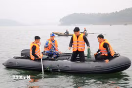 Lực lượng chức năng tìm kiếm các nạn nhân vụ chìm tàu khách tại hồ Thác Bà, Lào Cai ngày 22/2. (Ảnh: Đinh Thùy/TTXVN)