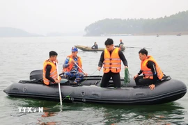 Lực lượng chức năng tìm kiếm các nạn nhân vụ chìm tàu khách tại hồ Thác Bà, Lào Cai ngày 22/2. (Ảnh: Đinh Thùy/TTXVN)