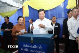 Tổng Bí thư, Chủ tịch nước Lào Thongloun Sisoulith bỏ phiếu tại Đơn vị bầu cử số 01 bản Thaphalanxay, quận Sisattanak, Khu vực bầu cử số 1, thủ đô Vientiane. (Ảnh: Xuân Tú/TTXVN)