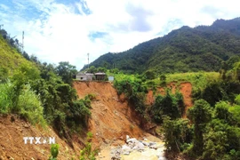 Ta-luy âm bị sạt lở nên nhiều ngôi nhà của người dân bản Xói Voi (xã Nhôn Mai, huyện Tương Dương, Nghệ An) bị đe dọa nghiêm trọng. (Ảnh: TTXVN phát)