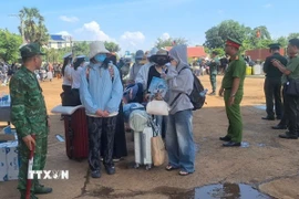 Lực lượng chức năng Việt Nam-Campuchia làm thủ tục bàn giao, tiếp nhận 353 công dân Việt Nam tại Cửa khẩu quốc tế Xa Mát, xã Tân Lập, tỉnh Tây Ninh. (Ảnh: TTXVN phát)