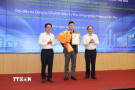 Lãnh đạo Ủy ban Nhân dân thành phố Cần Thơ trao Giấy chứng nhận đăng ký đầu tư và hoa cho Công ty Cổ phần đầu tư Khu công nghiệp Mekong Cần Thơ. (Ảnh: Ngọc Thiện/TTXVN)