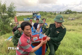 Lực lượng Đồn Biên phòng Tuy Hòa hỗ trợ người dân đưa tàu thuyền đến nơi an toàn. (Ảnh: Tường Quân/TTXVN)
