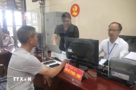 Cán bộ xã Cẩm Giàng - xã xa nhất vùng ven thành phố hướng dẫn người dân các thủ tục hành chính tại Trung tâm phục vụ hành chính công của xã. (Ảnh: Tiến Vĩnh/TTXVN)