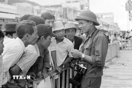 Phóng viên Hứa Kiểm của Thông tấn xã Việt Nam gặp gỡ quần chúng nhân dân Sài Gòn để đưa tin, ảnh về thắng lợi của Chiến dịch Hồ Chí Minh lịch sử 1975, giải phóng hoàn toàn miền Nam, thống nhất đất nước. (Ảnh: TTXVN)