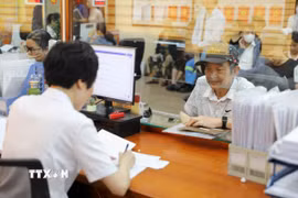 Cán bộ tại Điểm tiếp nhận, phục vụ hành chính công tiếp nhận và xử lý thủ tục hành chính cho người dân. (Ảnh minh họa: Quốc Lũy/TTXVN)