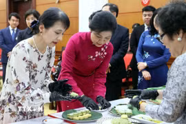 Phu nhân Ngô Phương Ly và Phu nhân Ishiba Yoshiko cùng làm bánh cốm truyền thống. (Ảnh: An Đăng/TTXVN)