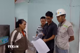 Người dân đối chiếu vết nứt được khảo sát trước thi công và hiện tại để có cơ sở giám định bồi thường thiệt hại. (Ảnh: Xuân Triệu/TTXVN)