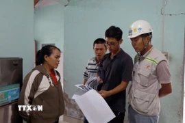 Người dân đối chiếu vết nứt được khảo sát trước thi công và hiện tại để có cơ sở giám định bồi thường thiệt hại. (Ảnh: Xuân Triệu/TTXVN)