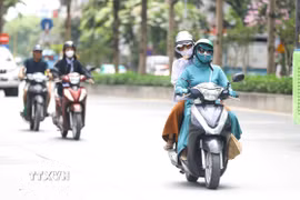 Người dân bịt kín mặt khi tham gia giao thông trong những ngày nắng nóng. (Ảnh: Lê Đông/TTXVN)