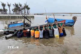Lực lượng Bộ đội Biên phòng Quảng Trị phối hợp với lực lượng liên quan tiến hành trục vớt tàu, thuyền của ngư dân bị ảnh hưởng sau bão. (Ảnh: TTXVN phát)