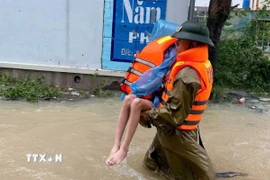 Chiến sỹ Phòng Cảnh sát phòng cháy, chữa cháy và cứu nạn, cứu hộ (Công an tỉnh Thanh Hóa) nỗ lực tiếp cận hộ dân ở thôn Bái, xã Trường Lâm (Thanh Hóa). (Ảnh: TTXVN phát)