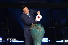 Thủ tướng Phạm Minh Chính thực hiện nghi thức vẽ tranh gốm ngũ sắc. (Ảnh: Dương Giang/TTXVN)