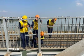 Công nhân đường sắt nỗ lực khắc phục sự cố cầu Ghềnh sau khi xảy ra tai nạn khiến tuyến đường sắt Bắc-Nam gián đoạn. (Ảnh: Sỹ Tuyên/TTXVN)