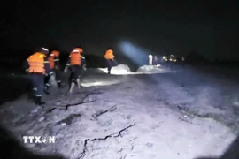 Các lực lượng chức năng tìm kiếm tung tích nạn nhân. (Ảnh: TTXVN phát)