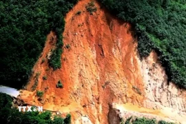 Khối lượng đất đá làm gẫy đứt khoảng 20m tại Km 24+800 (đỉnh suối Láo) thuộc tuyến đường Tỉnh lộ 433, xã Cao Sơn. (Ảnh: TTXVN phát)