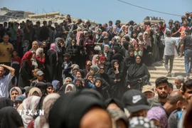 Người dân Palestine chờ được phát thực phẩm cứu trợ tại Gaza. (Ảnh: THX/TTXVN)