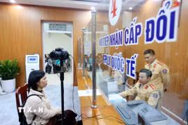 Cán bộ, chiến sỹ Đội Sát hạch, cấp giấy phép lái xe cơ giới đường bộ (Phòng Cảnh sát Giao thông, Công an thành phố Hà Nội) làm thủ tục cấp, đổi giấy phép lái xe cho công dân. (Ảnh: Phạm Kiên/TTXVN)