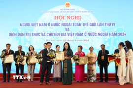 Tổng Biên tập Tạp chí Hương Việt Phạm Khánh Nam nhận bằng khen của Bộ Ngoại giao vì đã có thành tích xuất sắc trong công tác xây dựng phát triển cộng đồng người Việt ở nước ngoài, hướng về quê hương đất nước. (Ảnh: TTXVN)