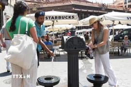 Người dân làm mát tại vòi nước công cộng dưới trời nắng nóng ở Madrid, Tây Ban Nha ngày 29/5/2025. (Ảnh: THX/TTXVN)