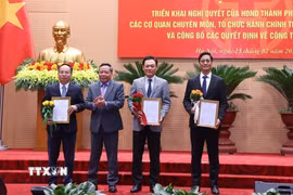 Phó Bí thư Thường trực Thành ủy Hà Nội Nguyễn Văn Phong trao quyết định điều động cán bộ. (Ảnh: Văn Điệp/TTXVN)