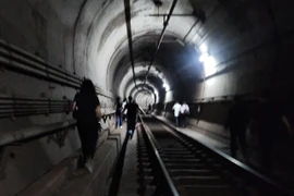 Hành khách được sơ tán khẩn cấp qua đường hầm. (Nguồn: Yonhap)