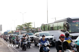 Phương tiện xếp hàng dài, di chuyển chậm qua các nút giao trên Quốc lộ 1, đoạn từ nút giao với đường Nguyễn Văn Linh đến đường Nguyễn Hữu Trí. (Ảnh: Tiến Lực/TTXVN)