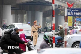 Cán bộ, chiến sỹ đội Cảnh sát Giao thông số 14 điều tiết, phân luồng giao thông tại tuyến đường Giải Phóng hướng về trung tâm thành phố. (Ảnh: Phạm Kiên/TTXVN)