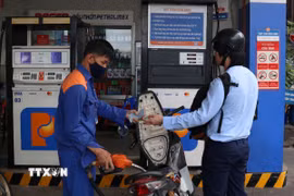 Người dân đổ xăng tại cây xăng góc đường 326 Trần Phú, thuộc phường An Đông, Thành phố Hồ Chí Minh. (Ảnh: Thanh Vũ/TTXVN)