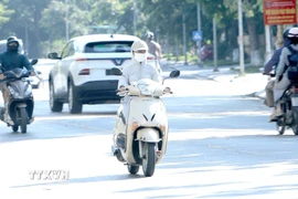 Trong ngày nắng nóng, trang phục kín mít là một lựa chọn tối ưu. (Ảnh: Hoàng Hùng/TTXVN)