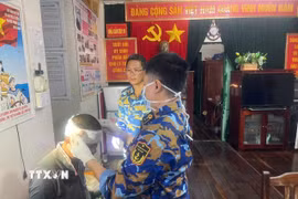 Băng bó vết thương cho ngư dân. (Ảnh: TTXVN phát)