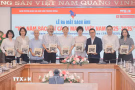Tổng giám đốc TTXVN Vũ Việt Trang tặng sách ảnh cho các đại biểu. (Ảnh: Minh Quyết/TTXVN)