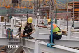 Người lao động hoàn thiện kết cấu thép mái nhà ga sân bay Long Thành. (Ảnh: Công Phong/TTXVN)