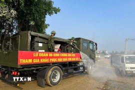Xe phun khử khuẩn của Lữ đoàn 86 - Binh chủng Hóa học tiến hành phun khử khuẩn, xử lý ô nhiễm môi trường tại các khu vực bị ngập úng trên địa bàn xã Trung Giã. (Ảnh: Quốc Lũy/TTXVN)