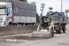 Thu gom lớp áo đường bị hư hỏng. (Ảnh: Mai Trang/TTXVN)