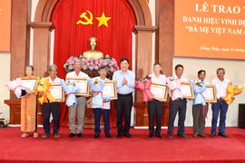 Chủ tịch Ủy ban Nhân dân tỉnh Phạm Thành Ngại trao Bằng công nhận và hoa cho thân nhân các mẹ Việt Nam anh hùng. (Nguồn: Cổng thông tin điện tử Đồng Tháp)