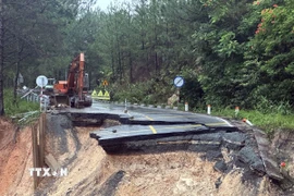 Lực lượng chức năng bố trí phương tiện tại khu vực sụt lún trên đèo Mimosa. (Ảnh: Chu Quốc Hùng/TTXVN)