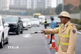 Cảnh sát giao thông điều tiết, phân luồng phương tiện. (Ảnh minh họa: Phạm Kiên/TTXVN)