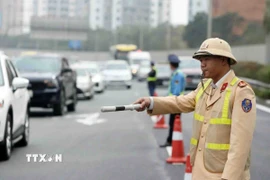 Cảnh sát giao thông điều tiết, phân luồng phương tiện. (Ảnh: Phạm Kiên/TTXVN)