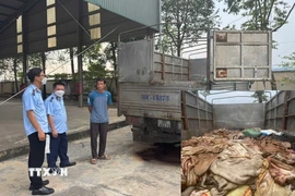 Cơ quan chức năng kiểm tra số hàng hóa là thực phẩm không rõ nguồn gốc. (Ảnh: TTXVN phát)