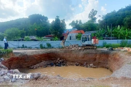 Đơn vị thi công tiến hành thả đá hộc xuống hố. (Ảnh TTXVN phát)