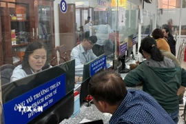 Cán bộ công chức giải thích, tư vấn, hướng dẫn để người dân nắm rõ các thủ tục hành chính. (Ảnh: Hữu Duyên/TTXVN)
