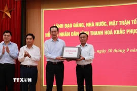 Đồng chí Trần Cẩm Tú trao quà của Lãnh đạo Đảng, Nhà nước hỗ trợ nhân dân tỉnh Thanh Hóa bị ảnh hưởng của bão số 10. (Ảnh: Hoa Mai/TTXVN)