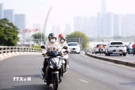 Người dân di chuyển trên cầu Khánh Hội, từ quận 1 qua quận 4, sáng 27/4/2024. (Ảnh: Hồng Đạt/TTXVN)