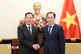 Bộ trưởng Bộ Ngoại giao Lê Hoài Trung tiếp Bộ trưởng Bộ Giáo dục và Thể thao Lào Thongsalith Mangnomek. (Ảnh: An Đăng/TTXVN)
